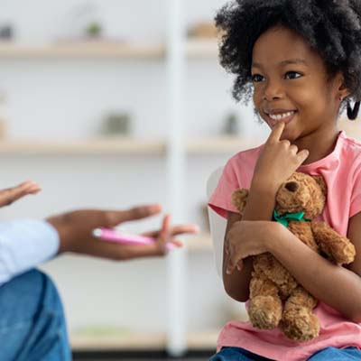 Child holding a teddy bear in therapy or counseling session